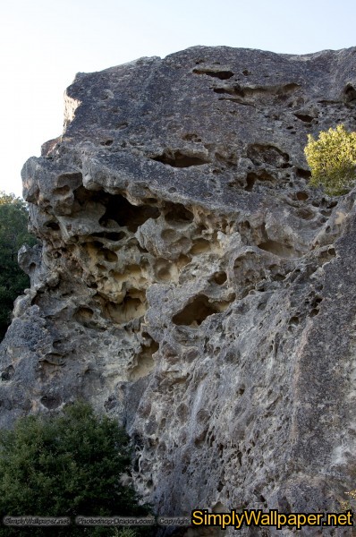 large rock outcropping with holes like swiss cheese