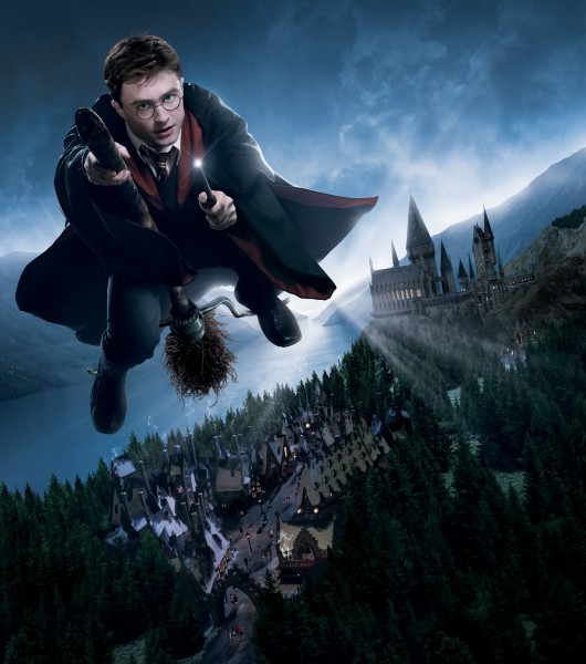 Harry Potter flys his broomstick over Hogsmeade Village and Hogwarts