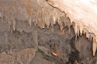 stalactites hang from the ceiling of the cave