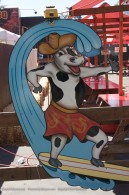 sign showing a cow riding a surf board