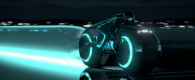 a light cycle speeds past from the world of tron legacy