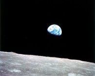 view of the earth rising above the surface of the moon