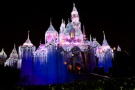 night time picture of Sleeping Beauty castle at Disneyland decorated for Christmas wallpaper
